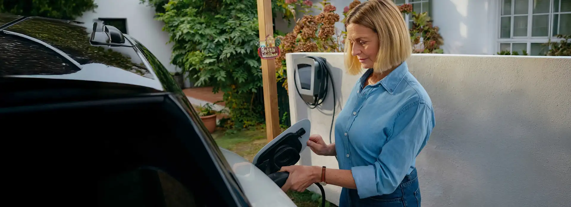 EnBW Frau Auto Laden Zuhause Elektromobilität Garten