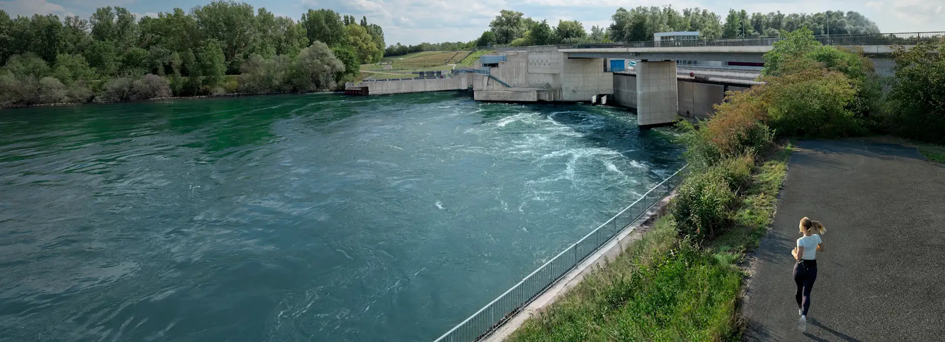 Joggerin läuft am Wasserkraftwerk vorbei