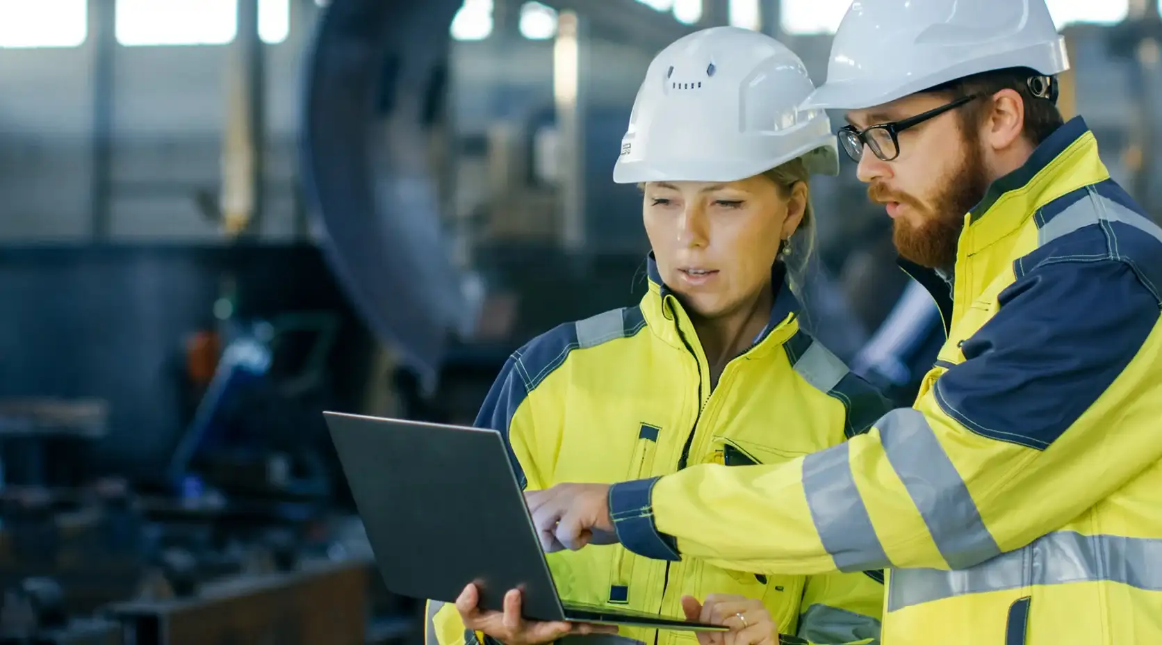 Techniker und Technikerin beraten sich zu einem Projekt