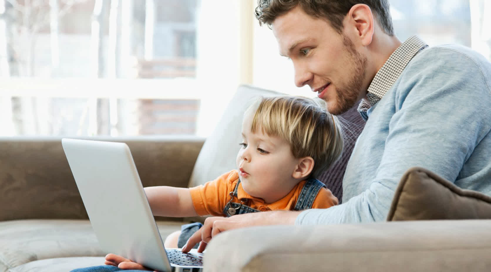 Vater und Kind am Laptop suchen günstigen Stromanbieter