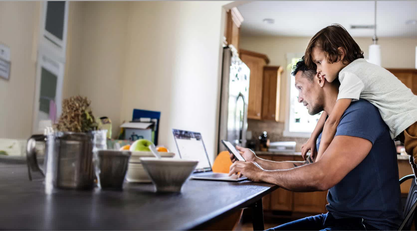 Vater und Sohn sitzen am Laptop.