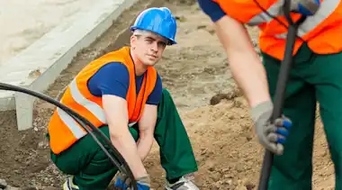 Bauarbeiter prüft Kabel