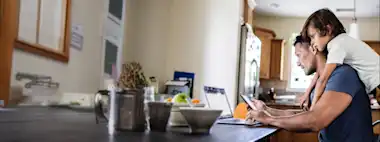 Vater und Sohn sitzen am Laptop.