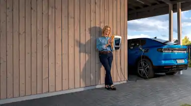 EnBW Frau Ladestation Elektroauto Wallbox Carport Smartphone Mavi Ladeübersicht