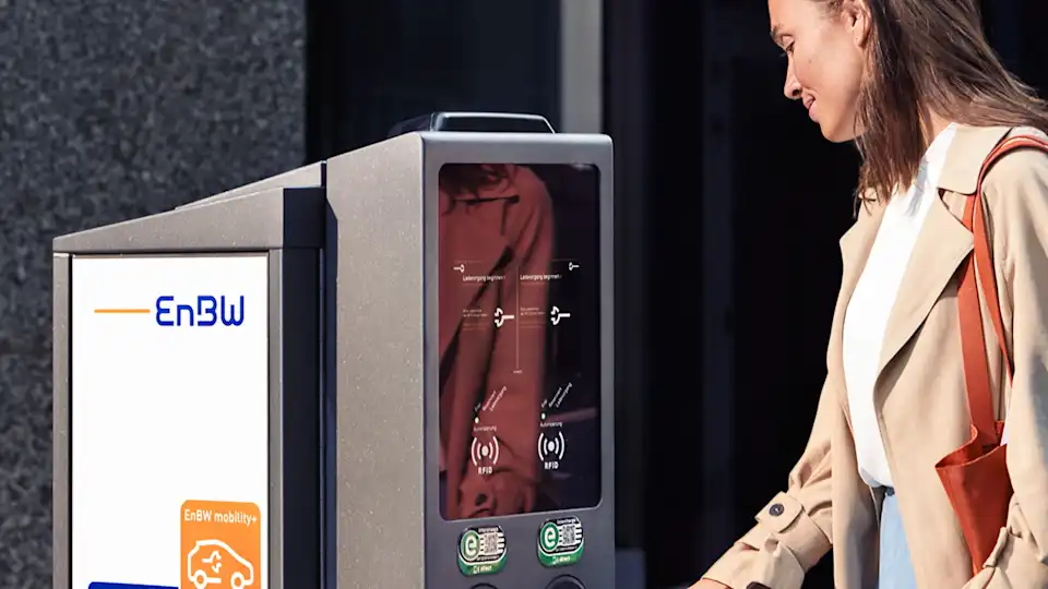 Frau lädt in der Stadt ihr Auto