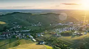Blick Vogelperspektive auf Dorf mit vielen Feldern und strahlender Sonne