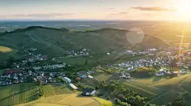 Blick Vogelperspektive auf Dorf mit vielen Feldern und strahlender Sonne