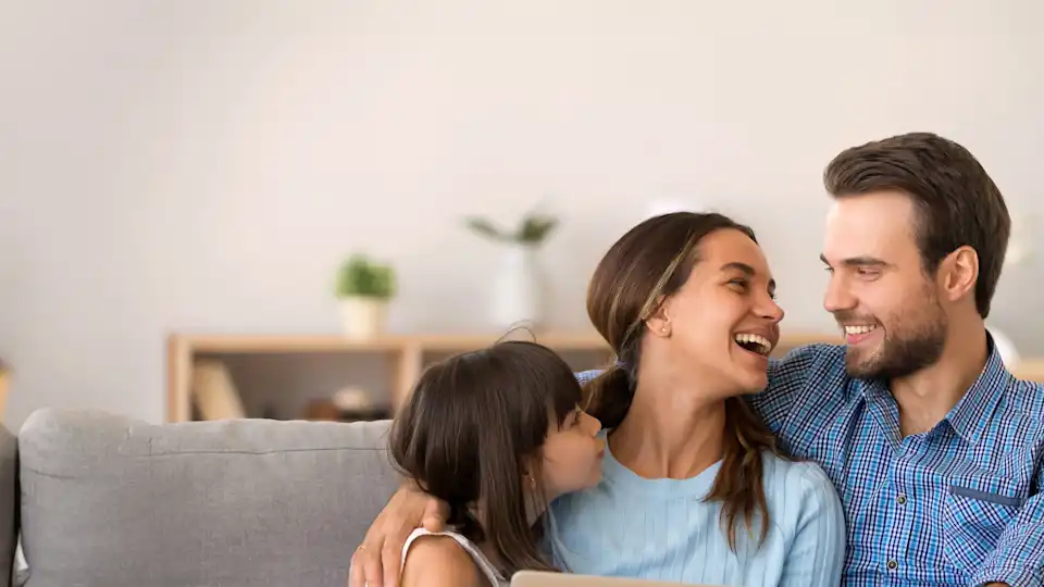 Familie sitzt auf dem Sofa und freut sich