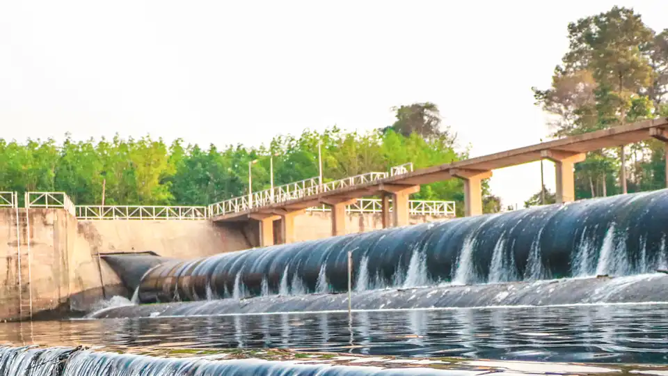 Wasserkraftwerk mit Beton-Stauwehr Konstruktion nutzt Seitenkanal und Überlaufvorrichtung