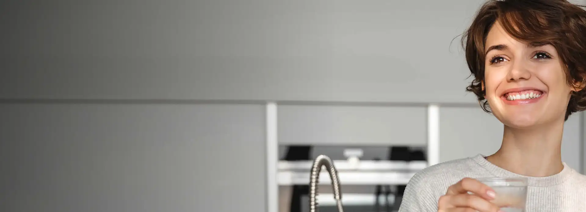 Frau trinkt Wasser aus einem Glas