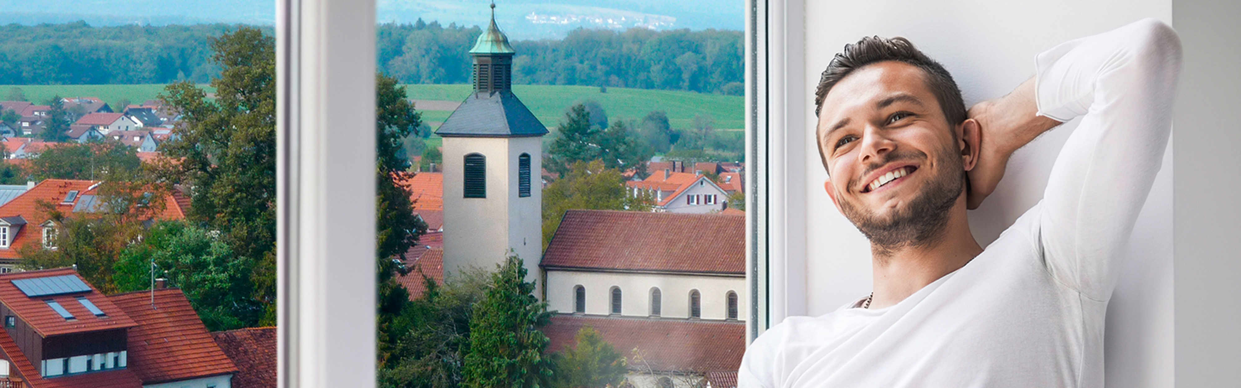 Mann auf der Fensterbank mit Aussicht auf Bad Boll