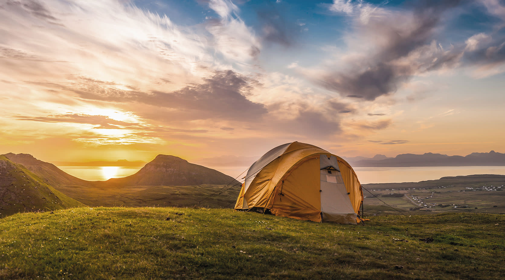 Trekking-Zelt bei Sonnenuntergang vor Berglandschaft