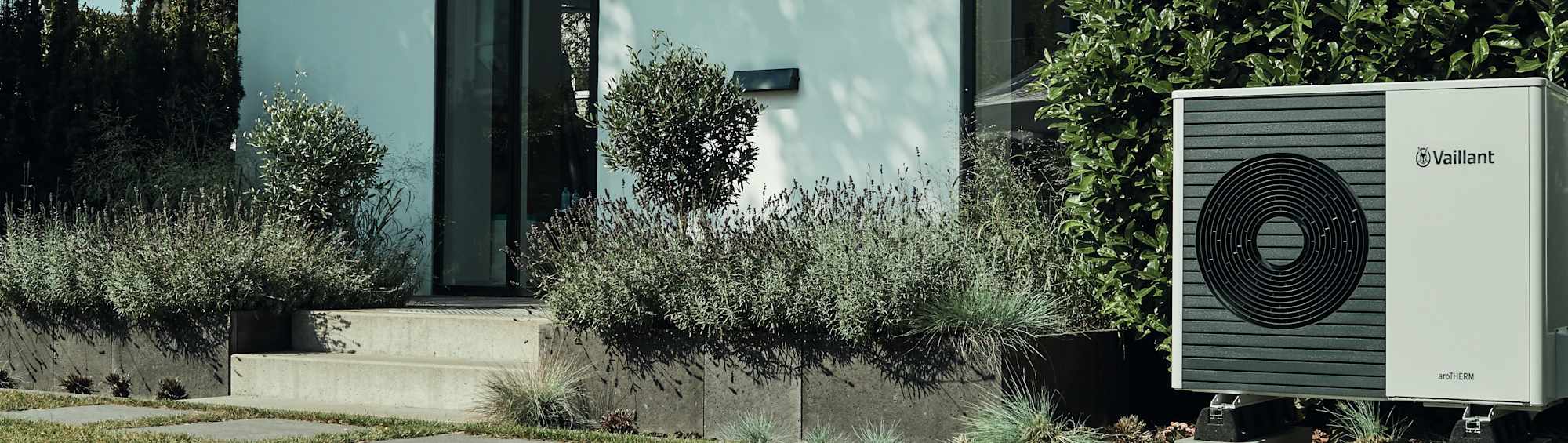 Decke mit Spielzeug vor einem Einfamilienhaus mit einer Wärmepumpe von Vaillant