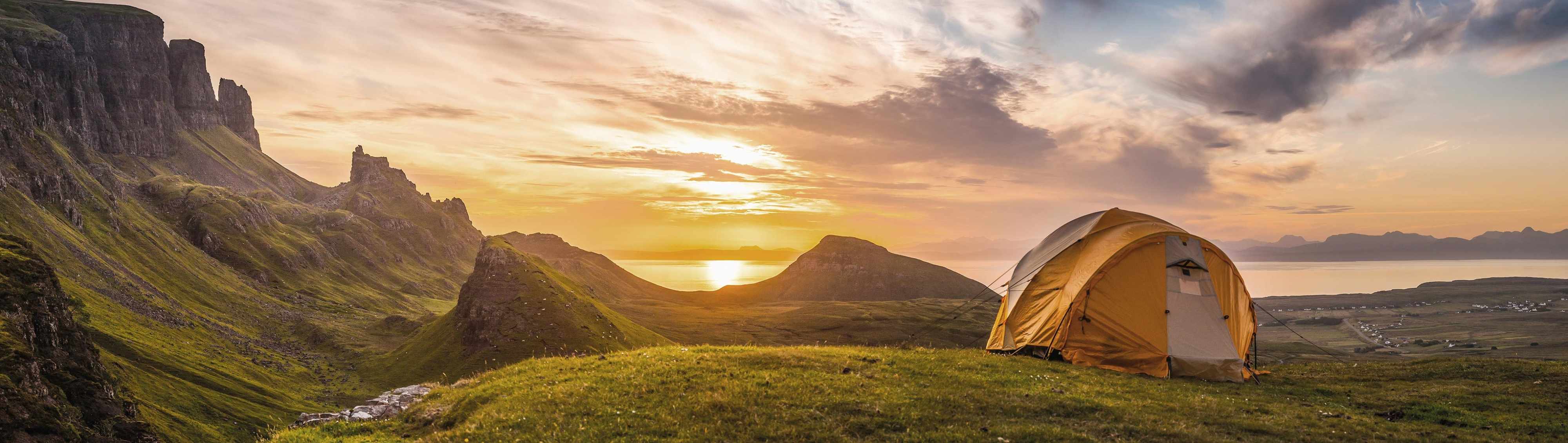 Zelt bei Sonnenuntergang vor Berglandschaft
