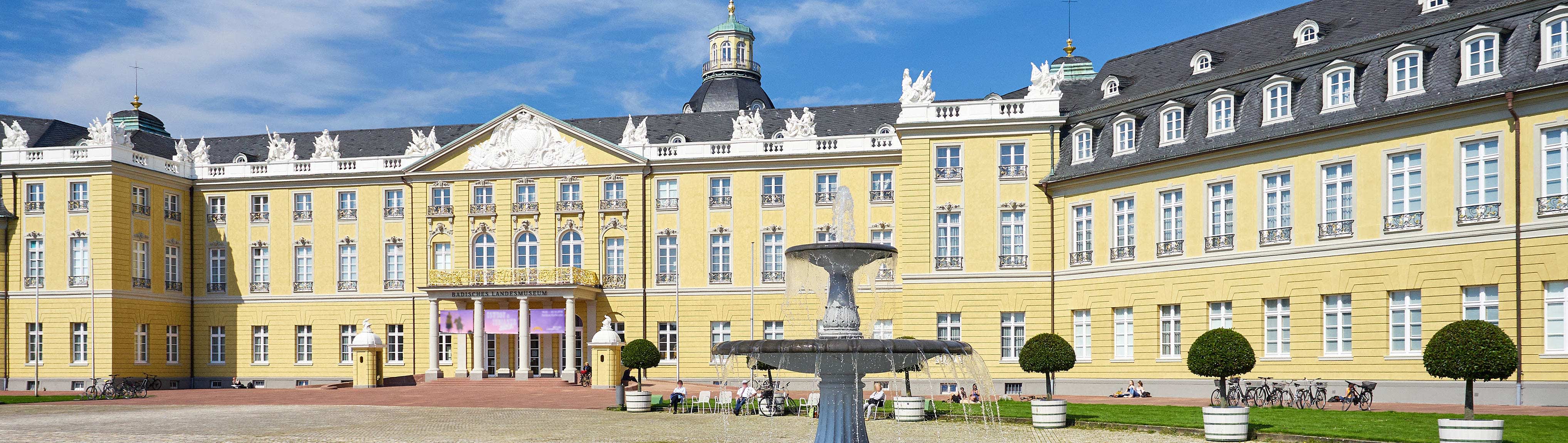 Ansicht des Schlosses in Karlsruhe mit Brunnen im Vordergrund