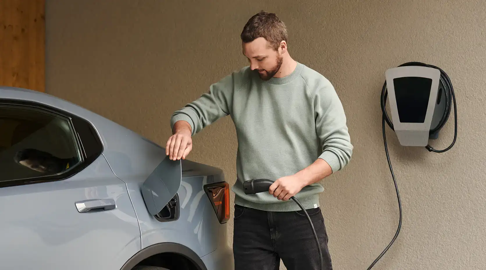 Mann lädt E-Auto