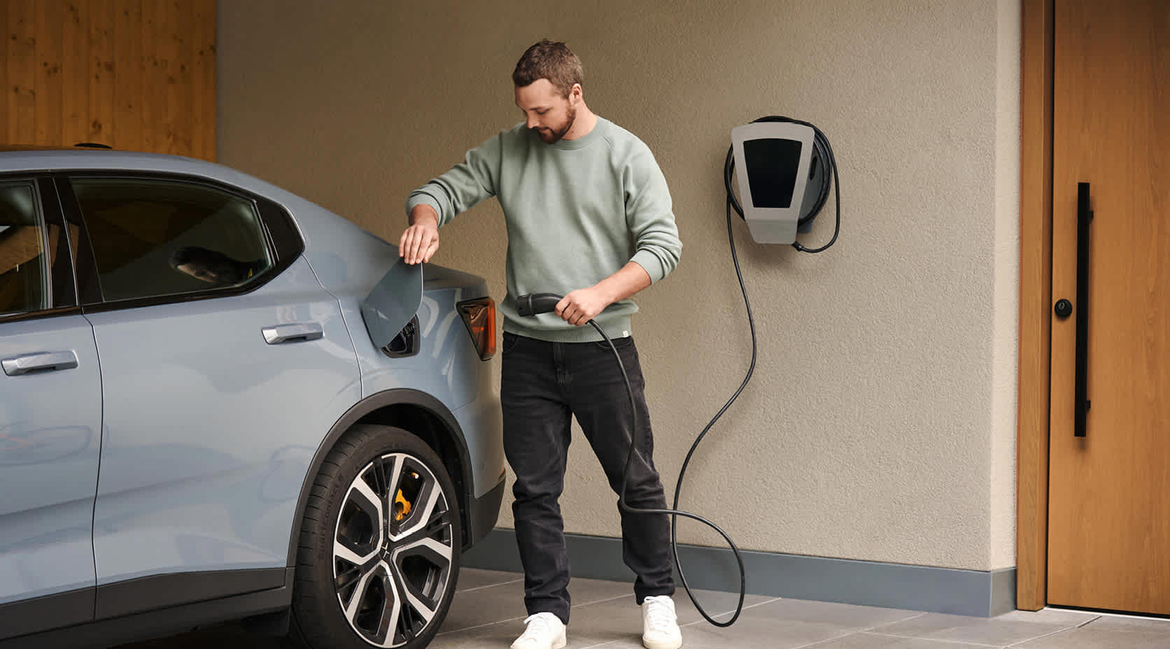 Mann läd E-Auto