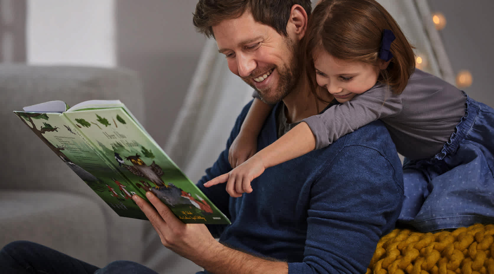 Vater liest Tochter aus einem Buch vor