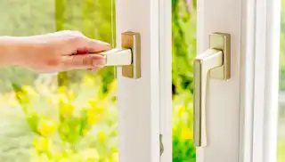 Hand öffnet Fenster zum Lüften