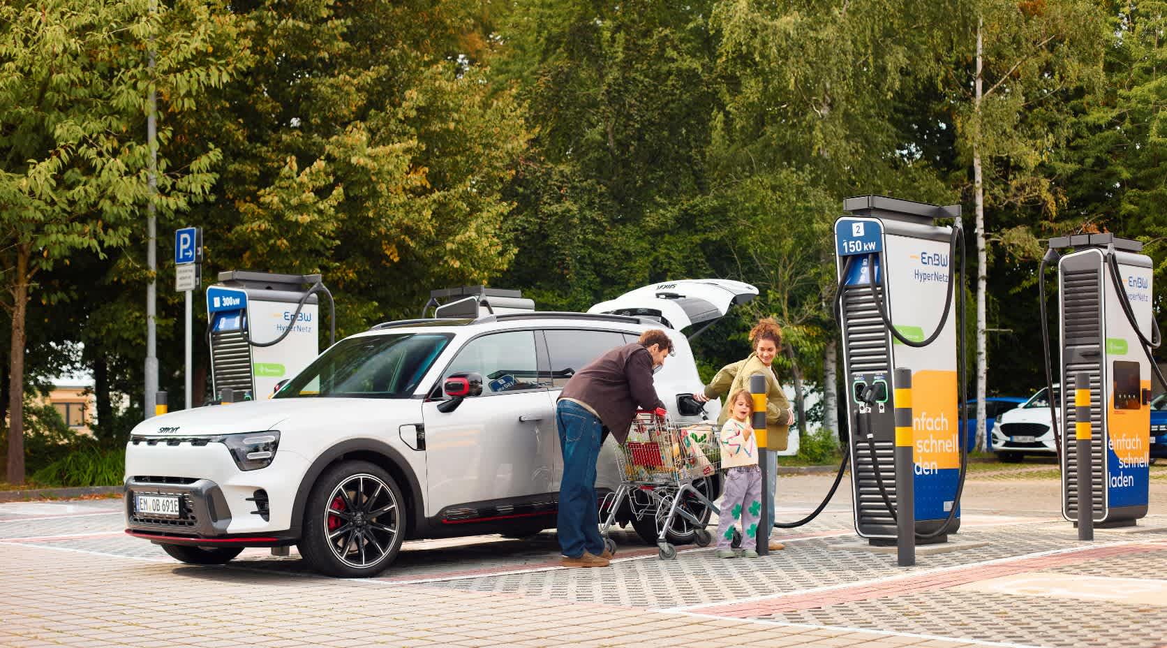 Familie lädt ihr Auto auf einem Supermarktparkplatz