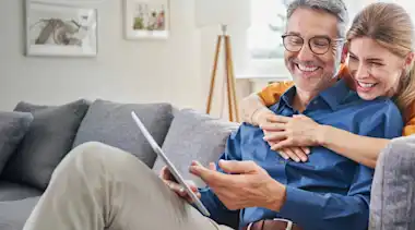Mann und Frau auf der Couch mit einem Tablet