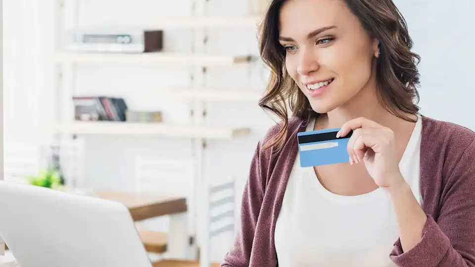 Frau mit Bankkarte am Laptop