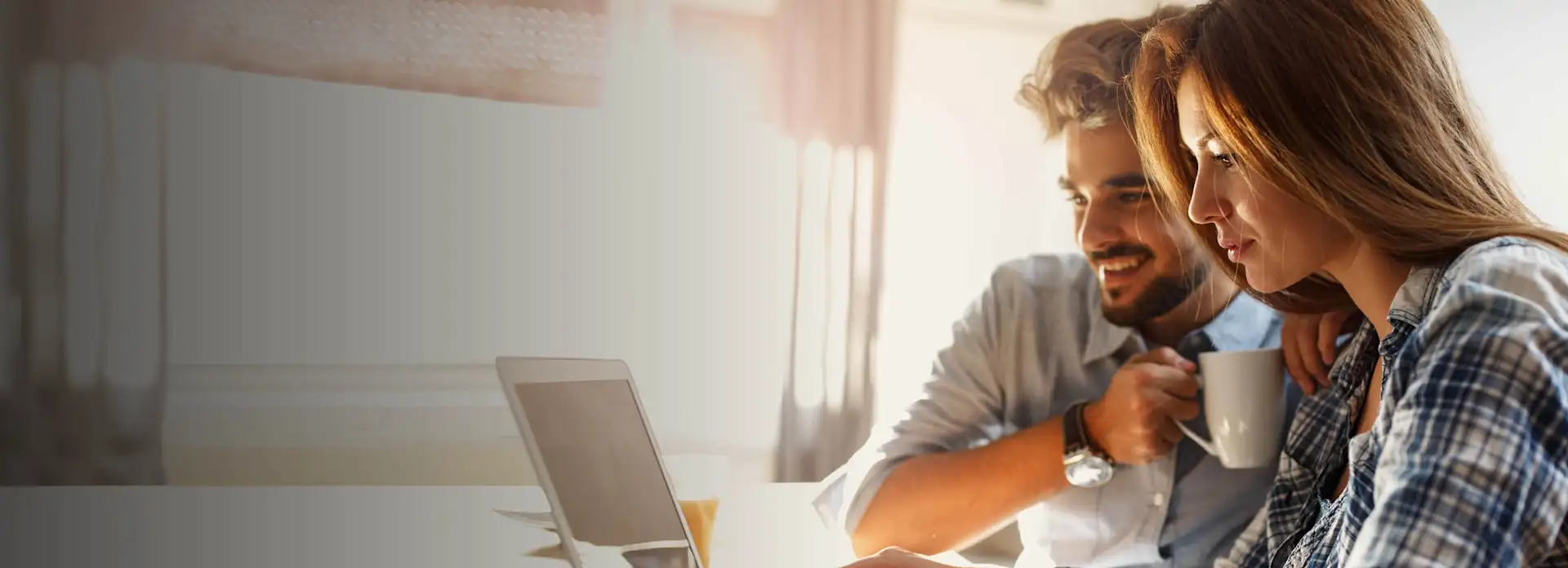 Braunhaarige Frau und Mann am Laptop Paar karierte Bluse