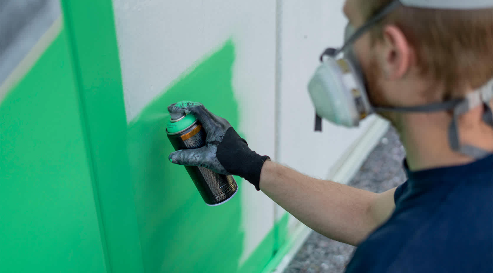 Künstler Poldy sprüht die Fassade der EVBZ grün ein
