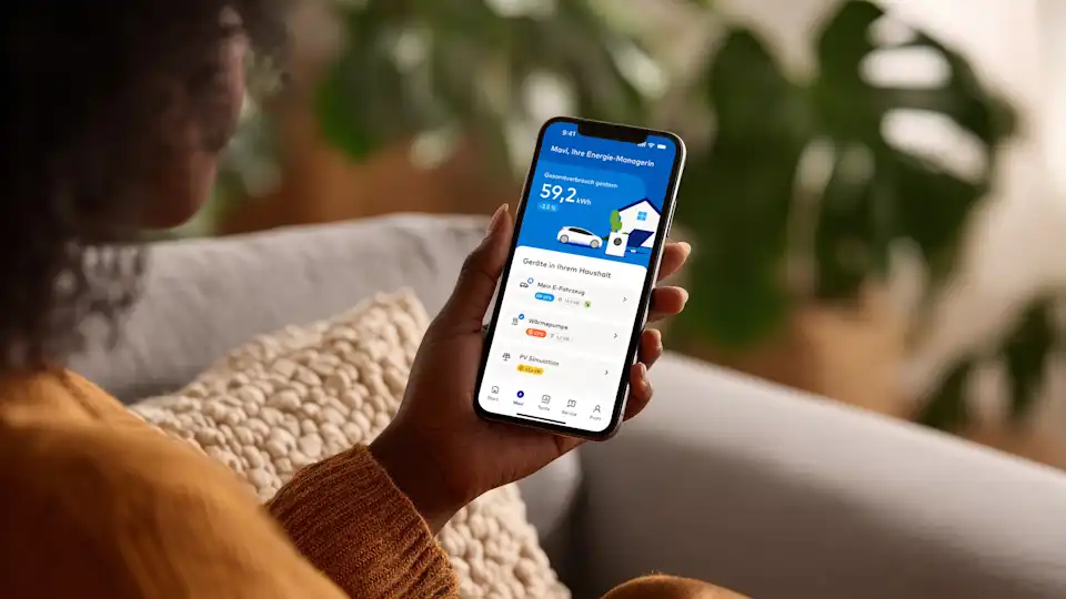 Frau mit Handyscreen auf dem EnBW Mavi zu sehen ist