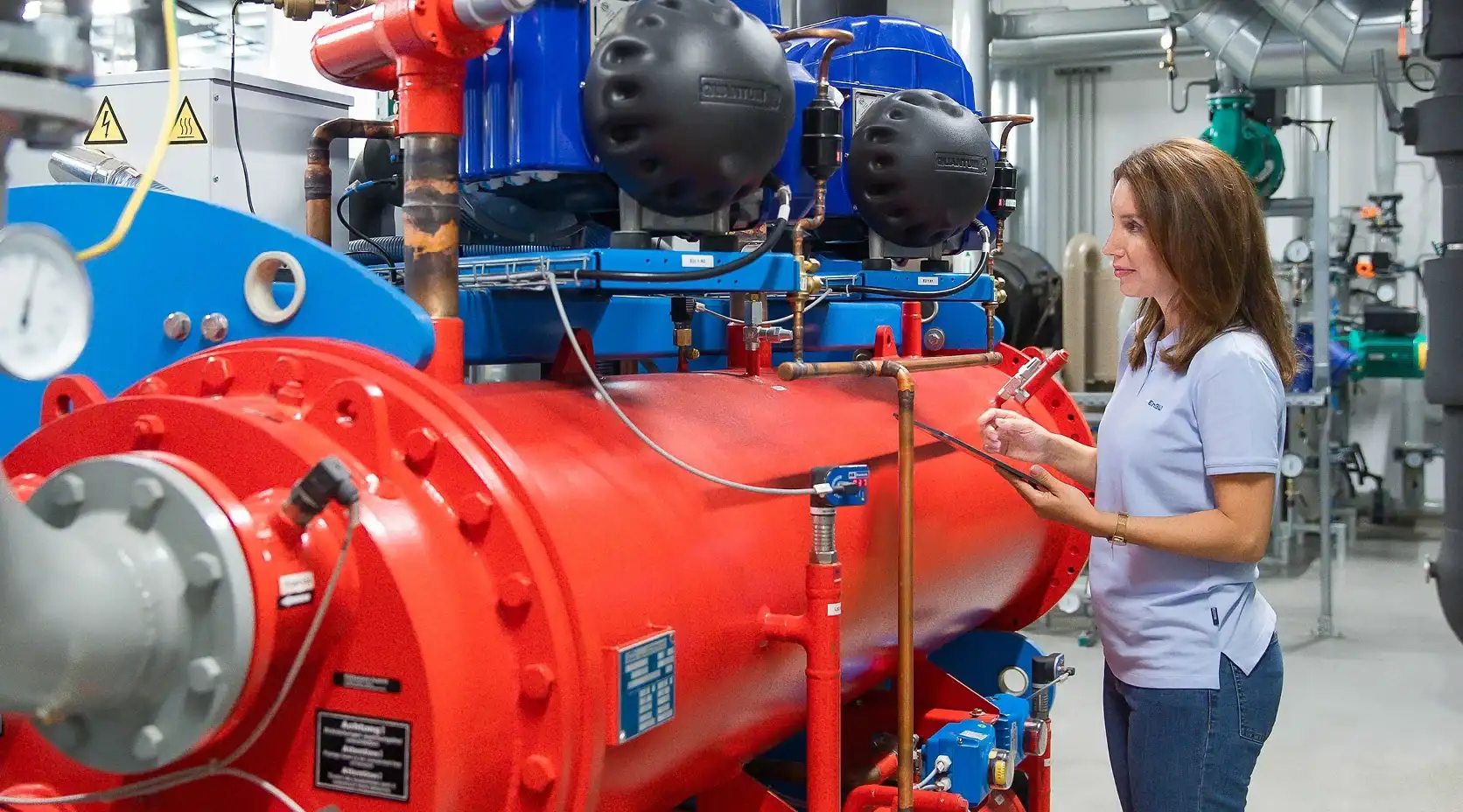 EnBW Contracting-Mitarbeiterin prüft eine Anlage