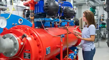 EnBW Contracting-Mitarbeiterin prüft eine Anlage