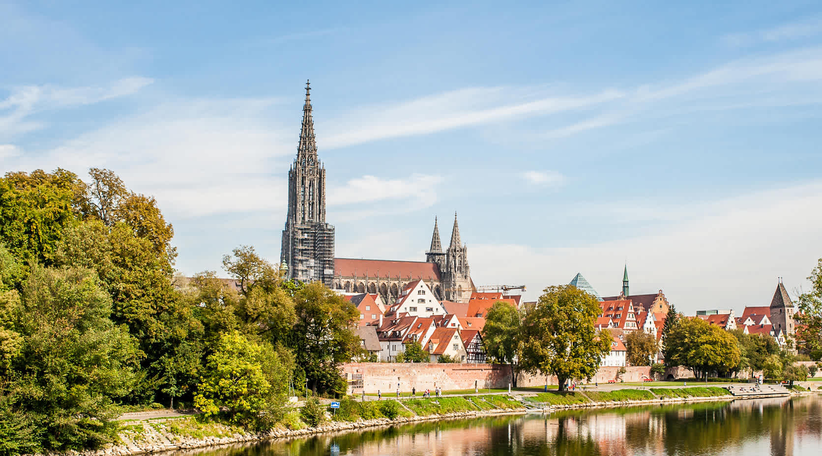 Dorf  mit Stadtmauer und Kirche an einem Fluss.