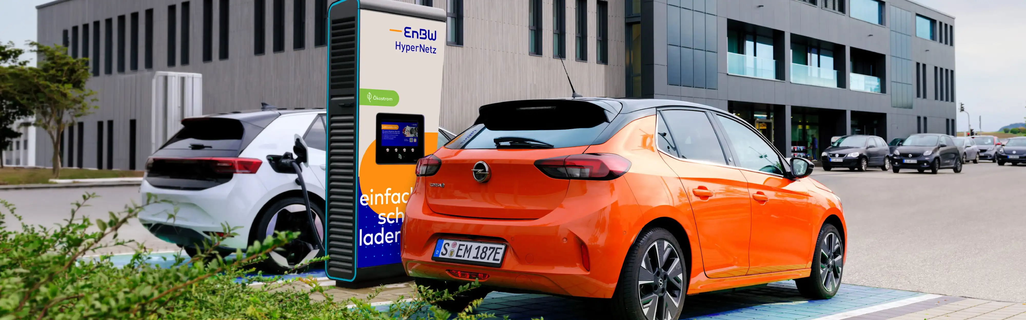 Auto lädt an Ladestation bei Sonnenschein