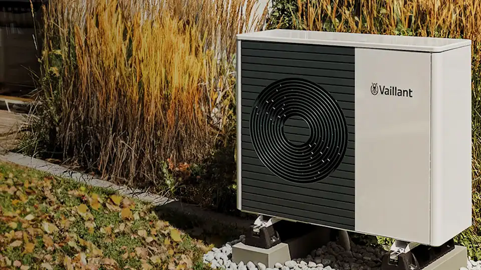 Vaillant Wärmepumpe in Garten auf Herbstwiese vor Holzterrasse