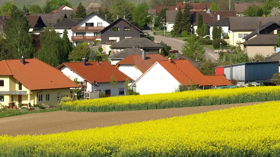 Kommunen Dorf mit Rapsfeld im Vordergrund