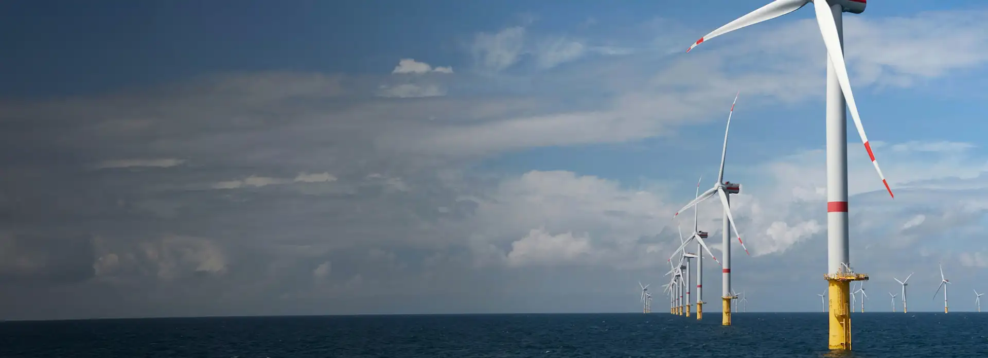 Offshore Windräder auf dem Wasser, im Hintergrund bewölkter Himmel