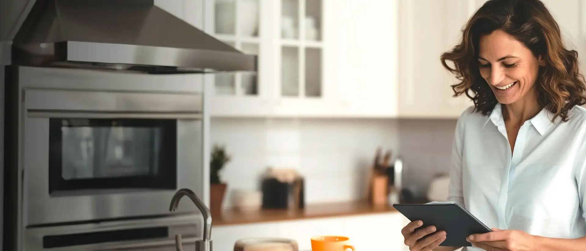 Lächelnde Frau mit Tablet in der Küche