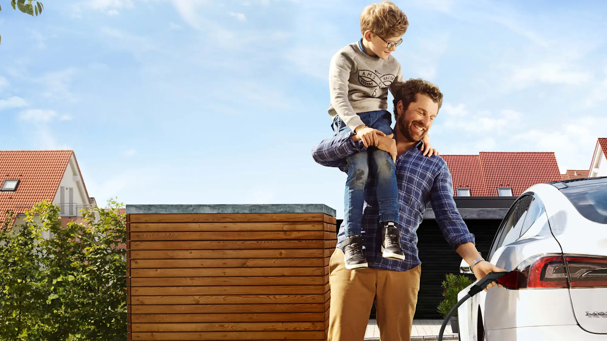 Mann und Sohn laden E-Auto zu Hause mit EnBW Ladestrom Pro