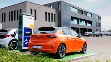 Elektroauto an Schnellladesäule auf Parkplatz vor Einkaufsmöglichkeit