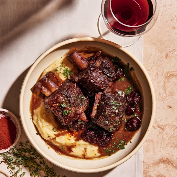 Pimentón-Braised Short Ribs with Dried Cherries Braised beef short ribs in glossy pimentón sauce over creamy polenta