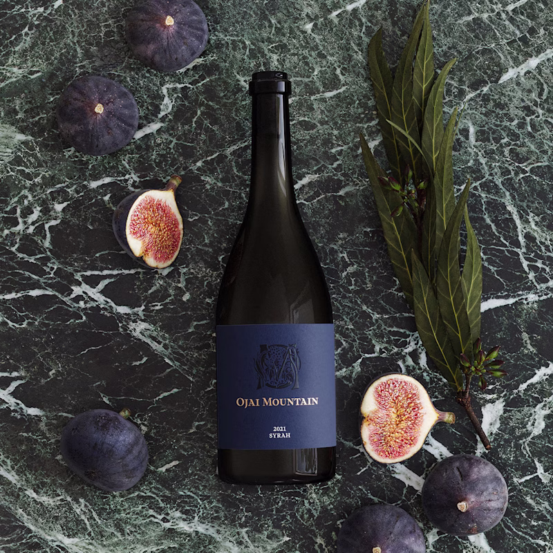 Ojai Mountain 2021 Syrah on green marble with fresh figs and bay leaves