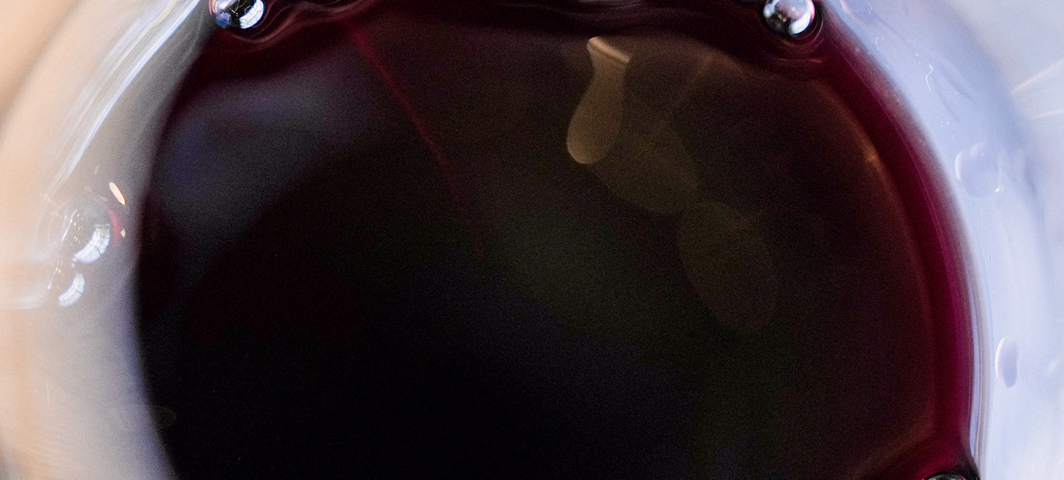 Close view of dark red wine in a tasting glass from above