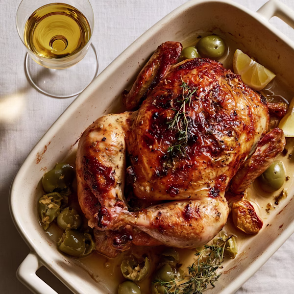 Roast Chicken with Preserved Lemon and Olives Golden roast chicken with preserved lemon, olives and thyme in roasting dish