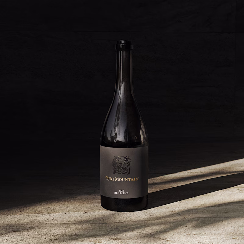 Ojai Mountain 2020 Red Blend bottle casting a long shadow on stone