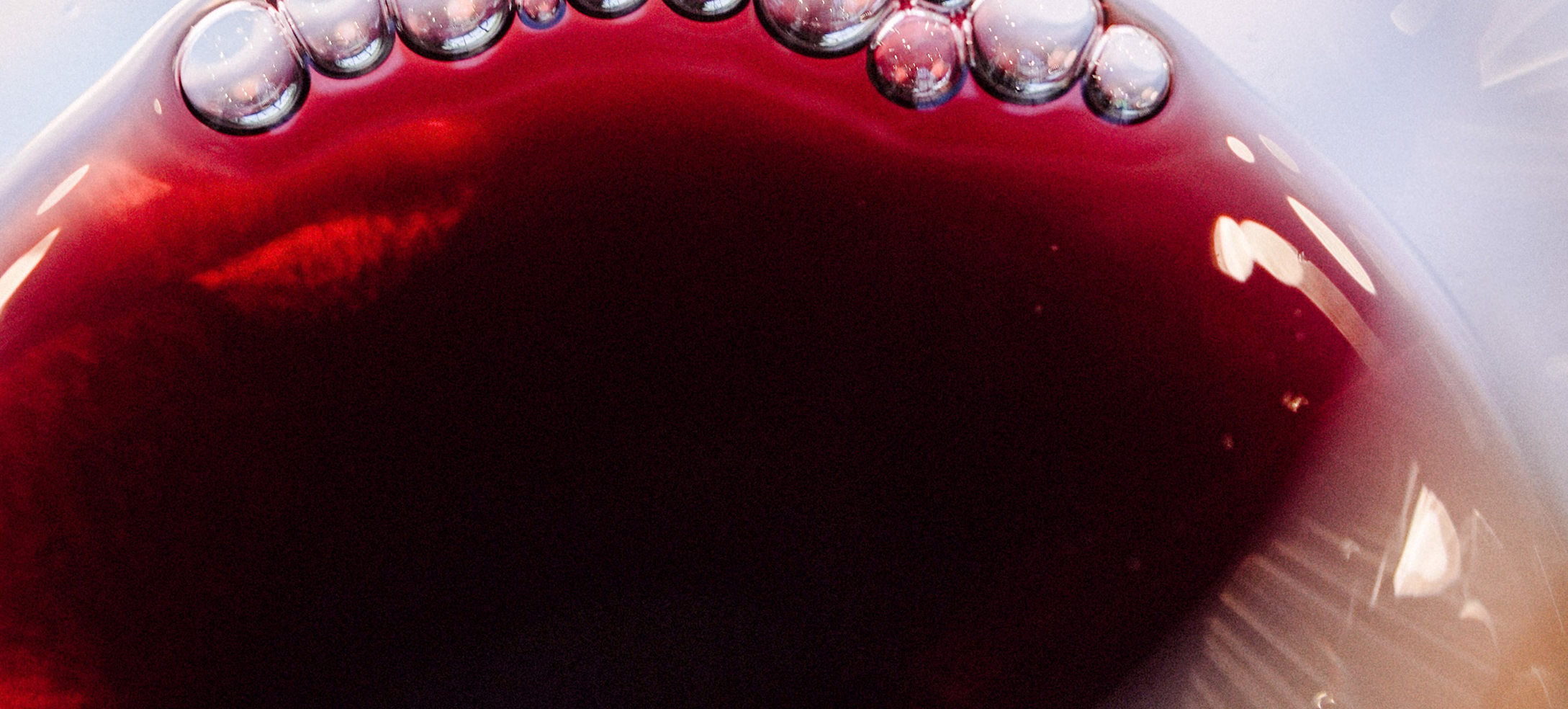 Close view of red wine surface with fine bubbles at the rim Close view of red wine surface with fine bubbles at the rim