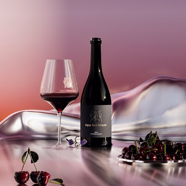 Ojai Mountain 2024 Tempranillo, Bottle and Glass Ojai Mountain 2024 Tempranillo bottle and glass with fresh cherries on an iridescent surface