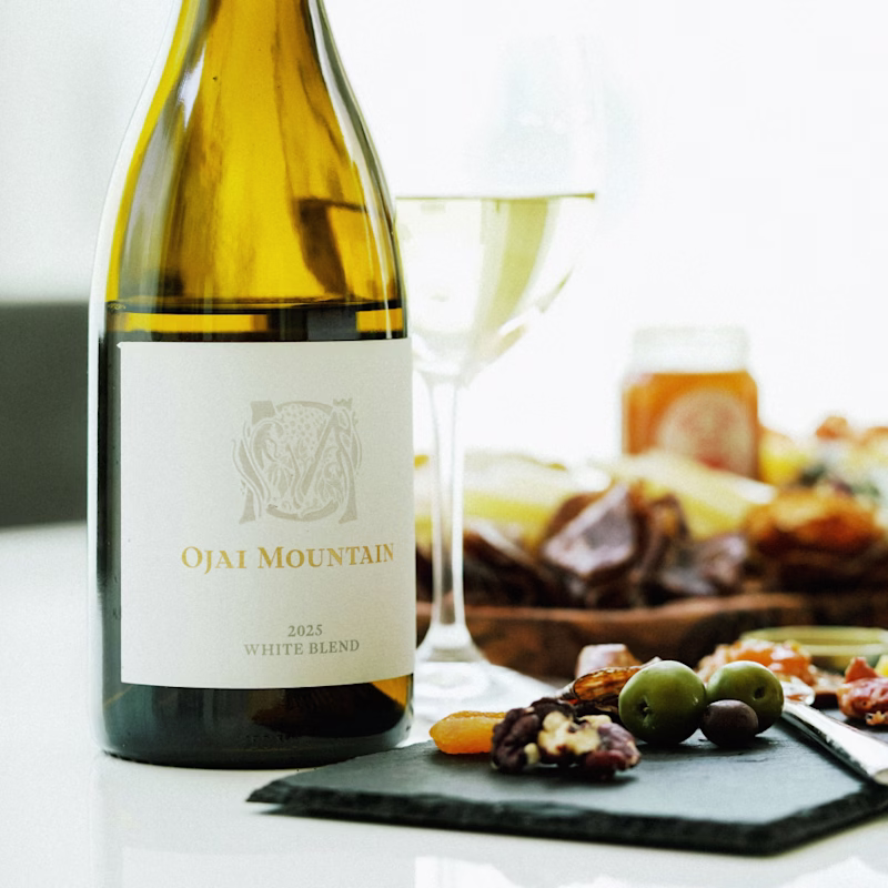 Estate White with a Cheese Board Ojai Mountain Estate White poured beside a cheese board with olives, nuts and honey