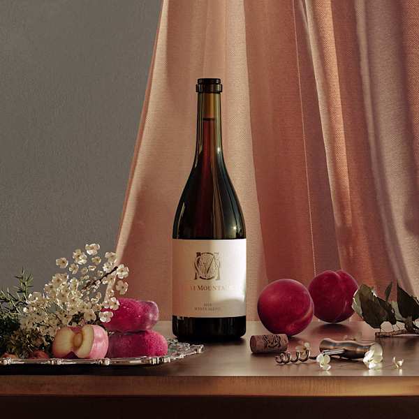 2025 White Blend with Peaches Ojai Mountain 2025 White Blend against peach curtains with peaches and a corkscrew