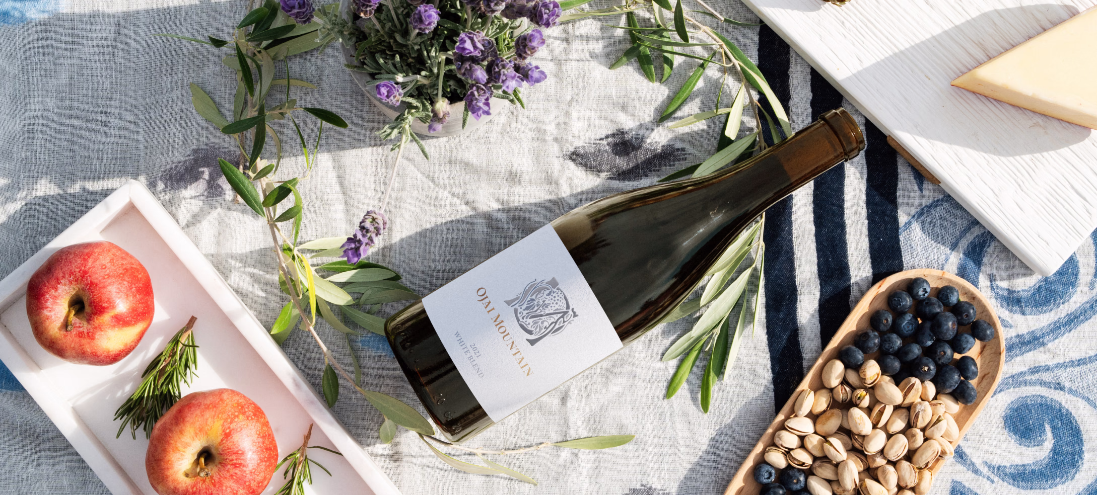 Ojai Mountain 2021 White Blend flatlay with apples, olives and pistachios