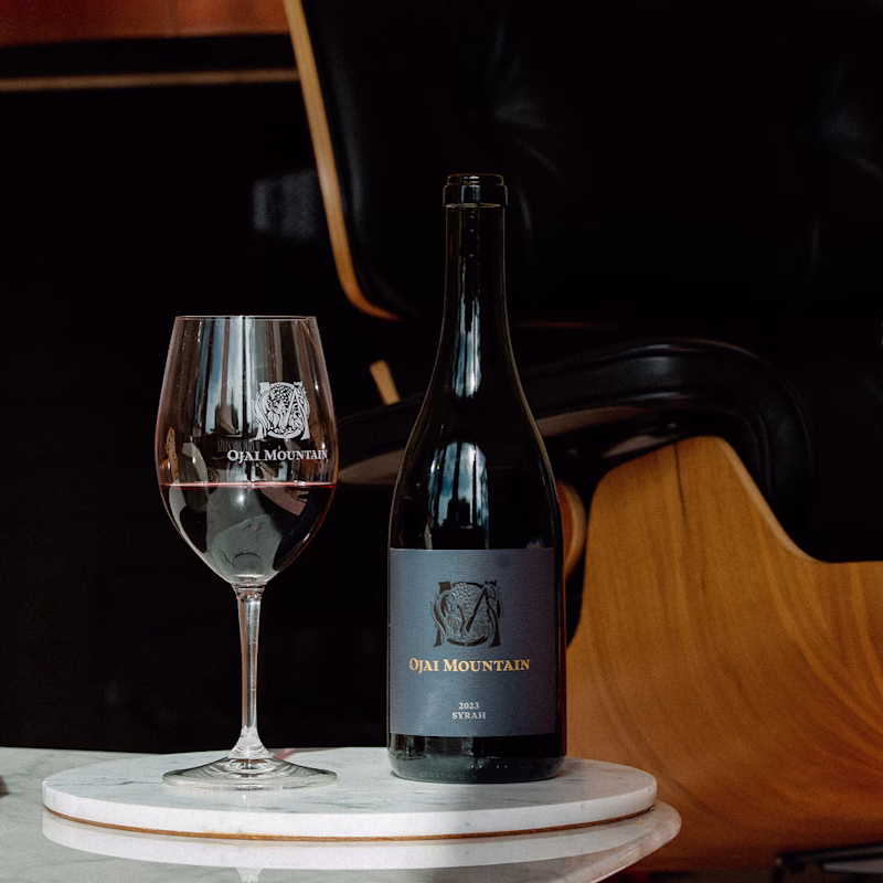 Ojai Mountain 2023 Syrah on a marble stand with an etched tasting glass